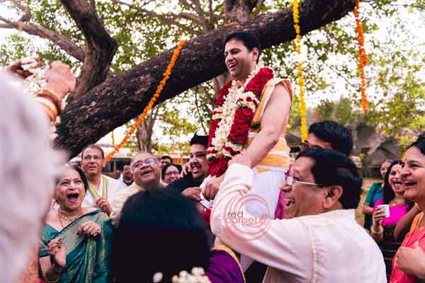 iyer ritual lifting the groom for varmala 
